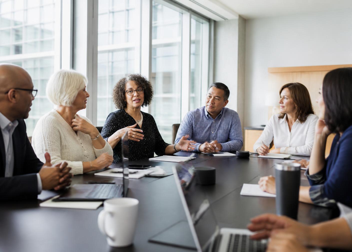 A diverse board of directors in discussion around a conference table